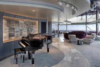 Interior moderno del MSC Yacht Club Top Sail Lounge con piano y cómodas áreas de descanso | MSC Cruceros