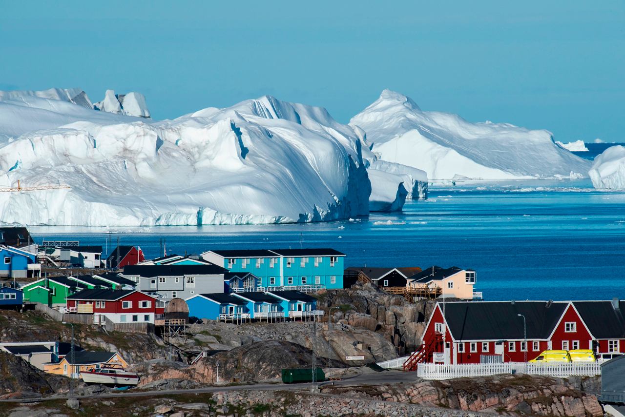 Village in Greenland with glaciers in the background and bright blue sea | MSC Cruises