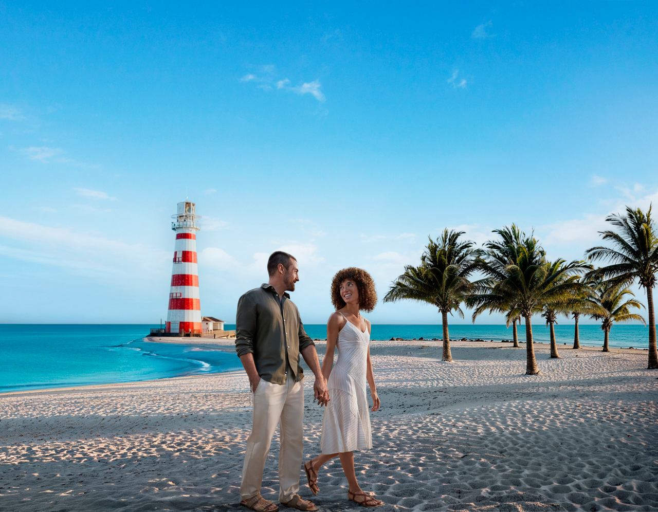 A couple enjoys a day at a beautiful beach with palm trees and a lighthouse in the background | MSC Cruises