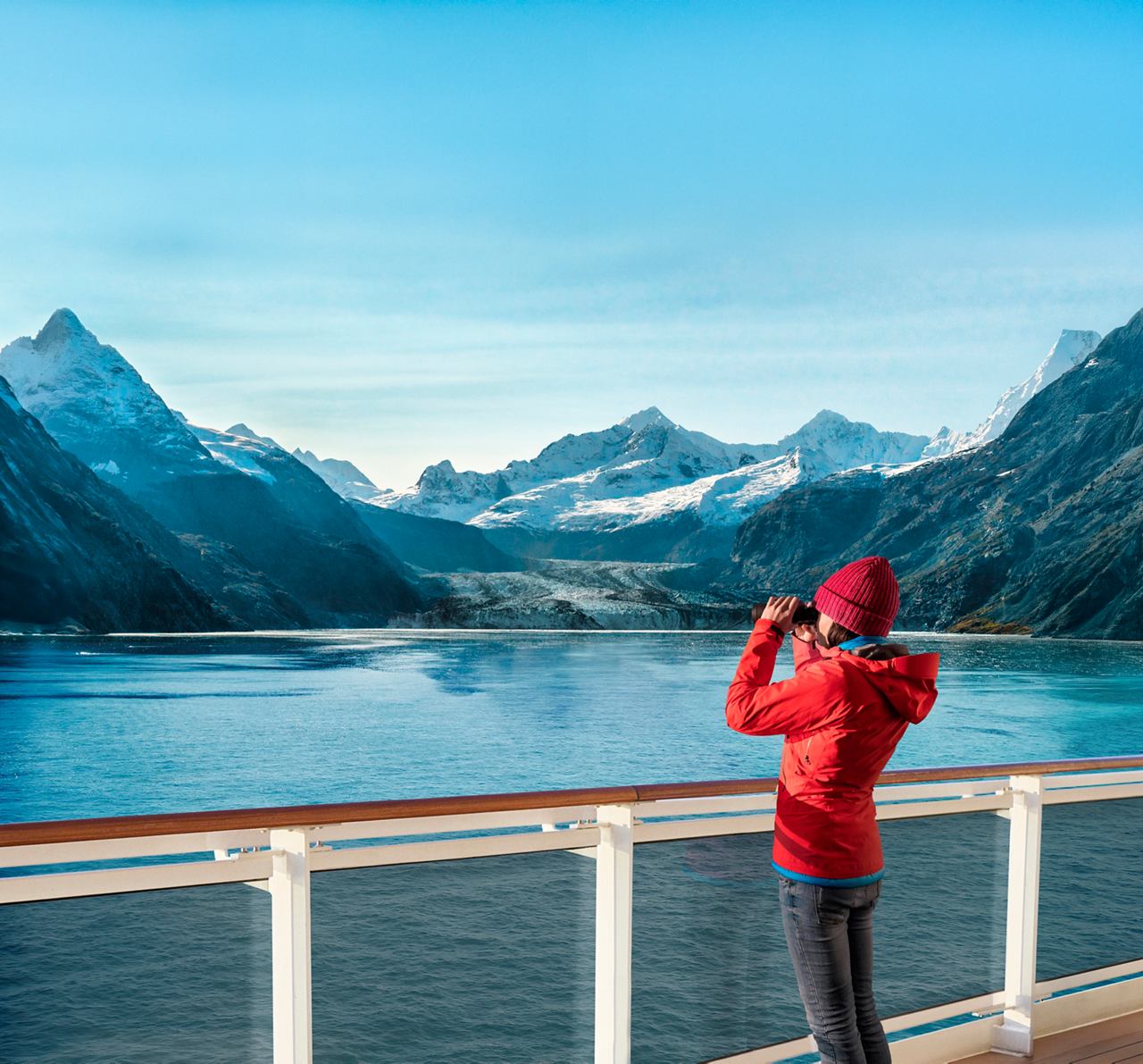 Woman on a cruise ship deck capturing the stunning view of mountains and a bay in Alaska | MSC Cruises