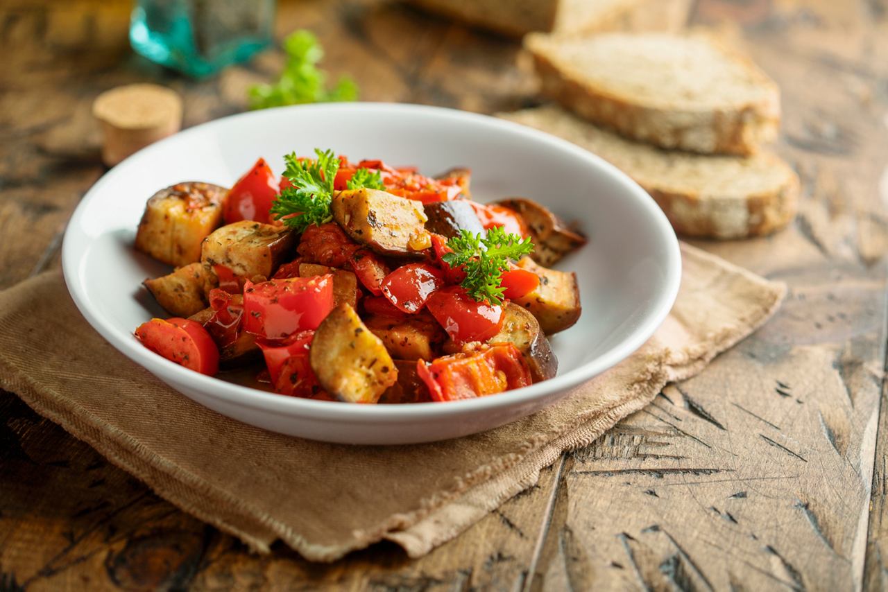 A colorful vegetable dish served with bread in a shallow bowl on a table | MSC Cruises