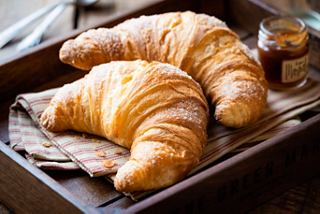 Croissants frescos servidos en una cesta acogedora con miel | MSC Cruceros