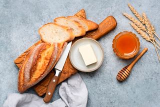 Pan fresco con mantequilla y miel servido en una tabla de madera | MSC Cruceros