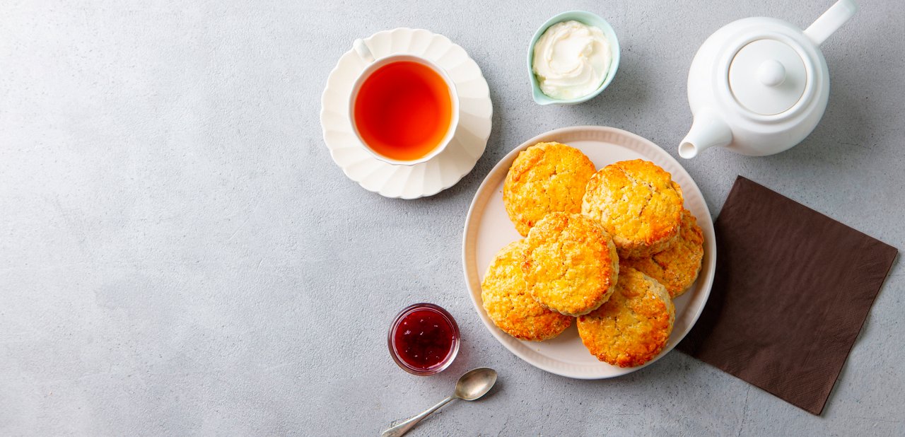 Cup of tea with cream and scones on a gray background | MSC Cruises