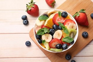 Colorido tazón de ensalada de frutas que incluye plátanos, fresas y arándanos | MSC Cruceros