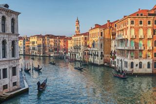 Canals and beautiful buildings in Venice, Italy, illuminated by the setting sun | MSC Cruises