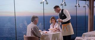 Una pareja disfruta de un almuerzo con servicio del personal, con un fondo de mar | MSC Cruceros