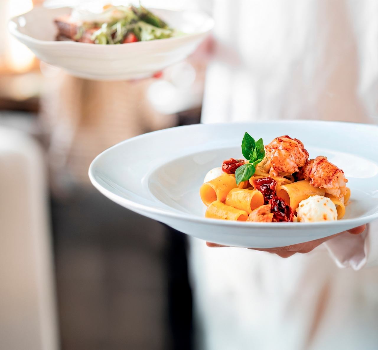 Waiter serving dish with lobster and paccheri pasta for welcome lunch on MSC Cruises | MSC Cruises