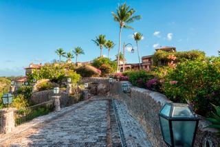 Schöner Weg in Altos de Chavon, gesäumt von Palmen und Blumen | MSC Cruises