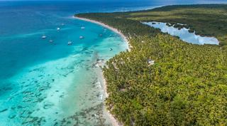 Aerial view of a coastline with turquoise water and lush vegetation | MSC Cruises