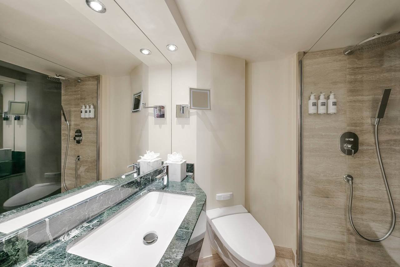 Baño moderno con dos lavabos y ducha, parte de la MSC Yacht Club Deluxe Suite | MSC Cruceros