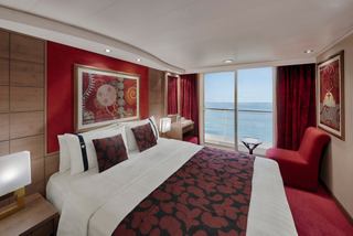 Stylish cabin with double bed and ocean view, illuminated by natural light | MSC Cruises