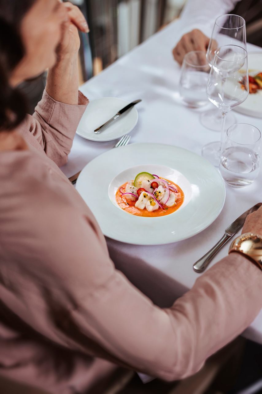 Woman serving main course with meat in MSC Yacht Club restaurant | MSC Cruises