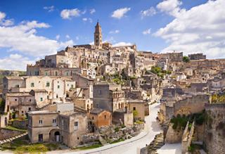 View of historic city with towers and cathedral under blue sky in Italy | MSC Cruises