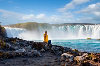 Woman on rock by Godafoss Waterfall during Northern Europe excursion in Iceland | MSC Cruises