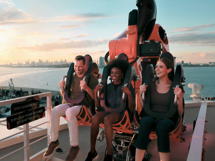 Guests enjoy a robotic roller coaster attraction on the cruise ship deck at sunset | MSC Cruises