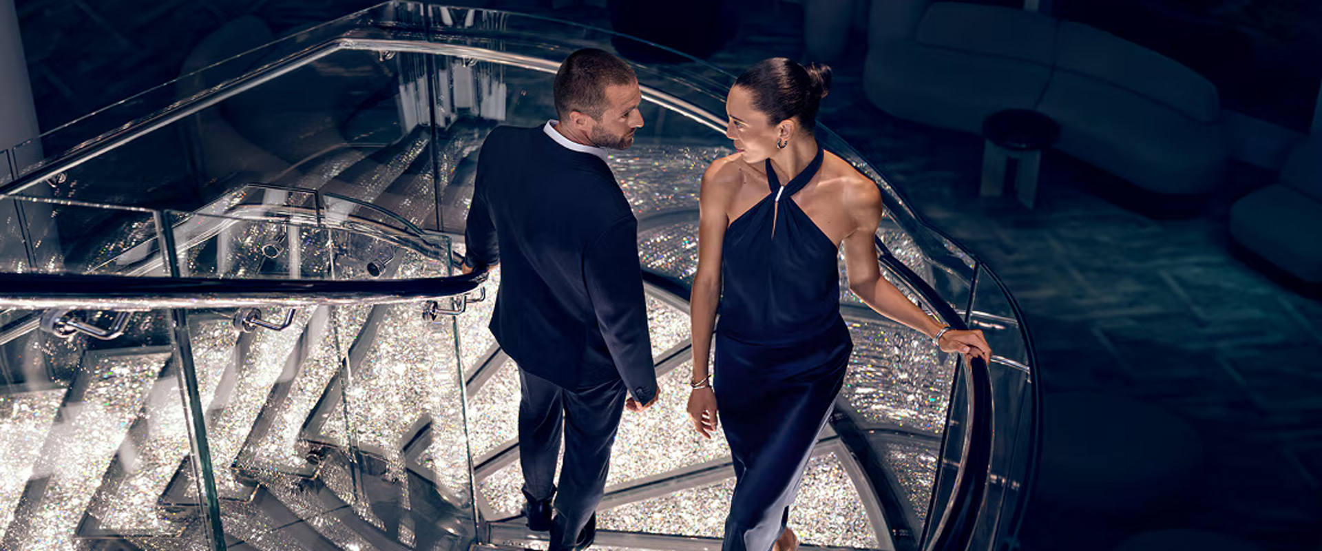 A couple walks up a stylish staircase on a cruise ship in a contemporary setting | MSC Cruises