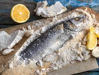Freshly prepared fish with lemon slices on a cutting board | MSC Cruises