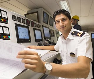 Giovane ufficiale al ponte che gestisce i sistemi di navigazione della nave | MSC Crociere