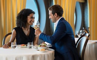 Ein Paar genießt einen intimen Moment an einem wunderschön gedeckten Tisch auf einem luxuriösen Kreuzfahrtschiff | MSC Cruises
