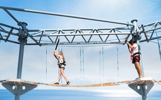 Guest crossing rope bridge on outdoor adventure course | MSC Cruises