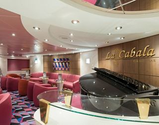 Eine warme und einladende Klavierbar mit bequemen Sitzgelegenheiten und elegantem Dekor | MSC Cruises