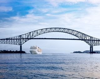 The bridge connects the shores with a cruise ship visible on calm waters in the background | MSC Cruises