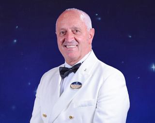 Crew officer in white formal uniform with confident posture | MSC Cruises