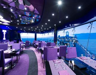 Einladende Atmosphäre im Galaxy Lounge auf der MSC Preziosa mit Tischen und Stühlen am Fenster | MSC Cruises