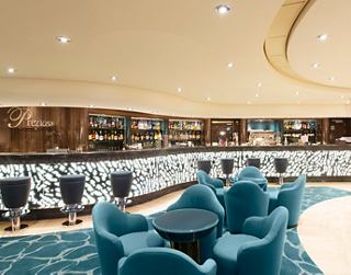 Eine moderne Bar mit bequemen Stühlen und einem Tisch, perfekt für angenehme Gespräche und Entspannung | MSC Cruises