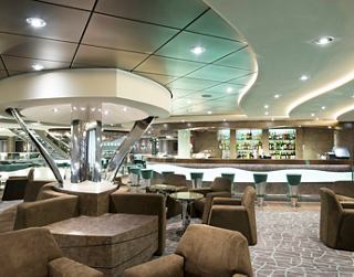 Eine moderne Bar mit gemütlichen Sitzgelegenheiten und einer Bibliothek an Bord der MSC Preziosa | MSC Cruises