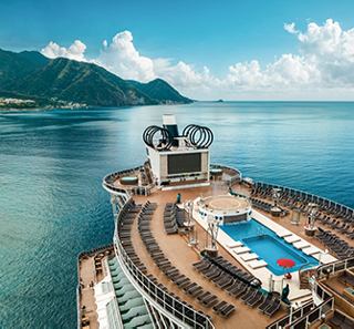 Pont d'un navire de croisière avec piscine, entouré de eaux sereines et de montagnes | MSC Croisières