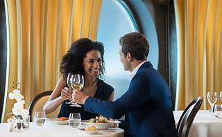 A couple enjoying a romantic meal together, surrounded by elegant decor and a stunning view | MSC Cruises