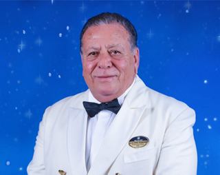 Crew officer posing with a smile in MSC setting | MSC Cruises