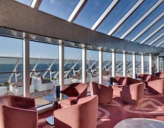 Eine stilvolle Lounge mit Panoramafenstern mit Blick auf den Ozean und bequemen Sitzgelegenheiten zum Entspannen | MSC Cruises