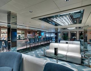 Ein stilvoller Barbereich mit modernen Sitzgelegenheiten und großen Fenstern für Drinks und Cocktails | MSC Cruises