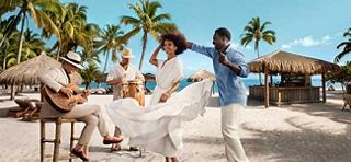 Vier Menschen genießen einen sonnigen Tag am tropischen Strand mit Palmen und Hütten | MSC Cruises