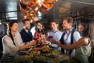 A group of friends enjoying drinks together in a lively setting, celebrating moments of joy and connection | MSC Cruises