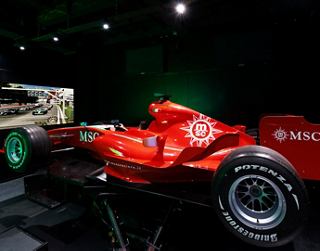 A vibrant red Formula 1 car is showcased in a well-lit environment, highlighting its sleek design and racing spirit | MSC Cruises