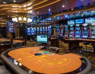 A vibrant casino interior featuring gaming tables and electronic slot machines in an inviting atmosphere | MSC Cruises