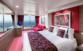 Une suite luxueuse avec un décor élégant, de grandes fenêtres et un coin salon confortable pour une expérience de croisière inoubliable | MSC Cruises