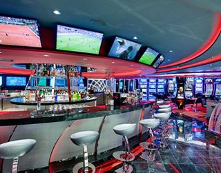 The modern casino bar offers a unique experience with multiple TVs and cozy seating | MSC Cruises