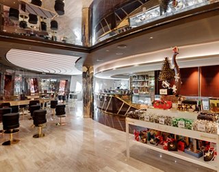 A spacious interior of a cruise ship dining area featuring a display of sweets and ice creams | MSC Cruises