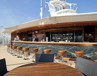 A welcoming bar area on the deck of MSC Splendida with seating and stunning ocean views | MSC Cruises
