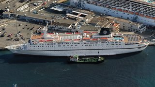Aerial view of a large cruise ship docked at a busy port, showcasing its impressive size and structure | MSC Cruises