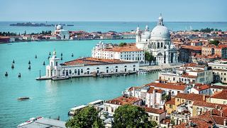Aerial view of a vibrant coastal city with boats and beautiful turquoise waters | MSC Cruises