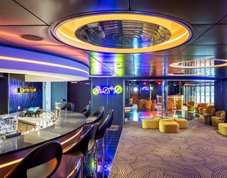 A vibrant lounge area with modern seating and colourful lighting, perfect for socialising and relaxation | MSC Cruises
