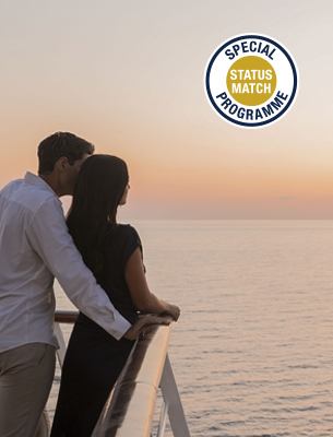 Ein Paar genießt den ruhigen Blick auf den Sonnenuntergang über dem Ozean, während es sich auf dem Balkon eines Kreuzfahrtschiffs umarmt | MSC Cruises