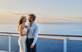 Ein Paar genießt einen romantischen Moment auf einem Kreuzfahrtschiff, umgeben von ruhigen Ozeanansichten bei Sonnenuntergang | MSC Cruises