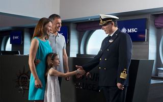 Eine Familie trifft den Kapitän des Kreuzfahrtschiffs und schüttelt ihm freundlich die Hand | MSC Cruises
